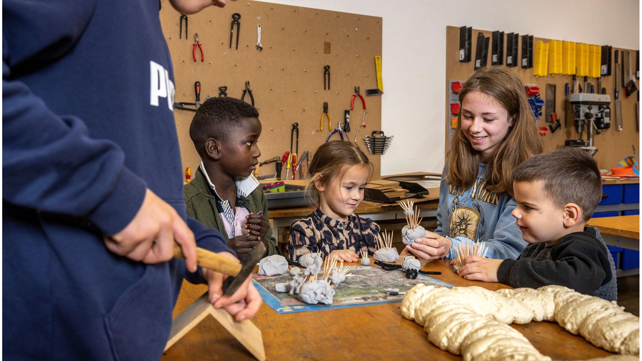 Kinderen van KC LEEF in Kessel zijn bezig met een creatieve knutselactiviteit in de werkplaats. Kinderen van KC LEEF in Kessel zijn bezig met een creatieve knutselactiviteit in de werkplaats.