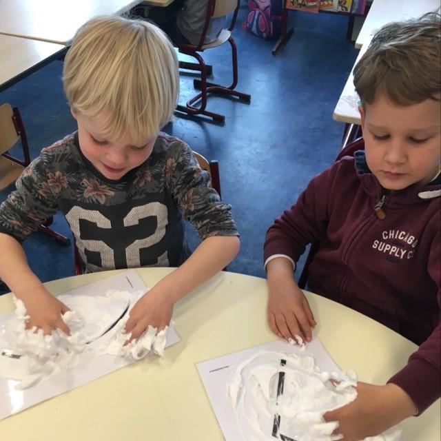 Kinderen van KC 't Echtenest' in Echten (Drenthe) spelen met schuim op hun werkbladen. Kinderen van KC 't Echtenest' in Echten (Drenthe) spelen met schuim op hun werkbladen.