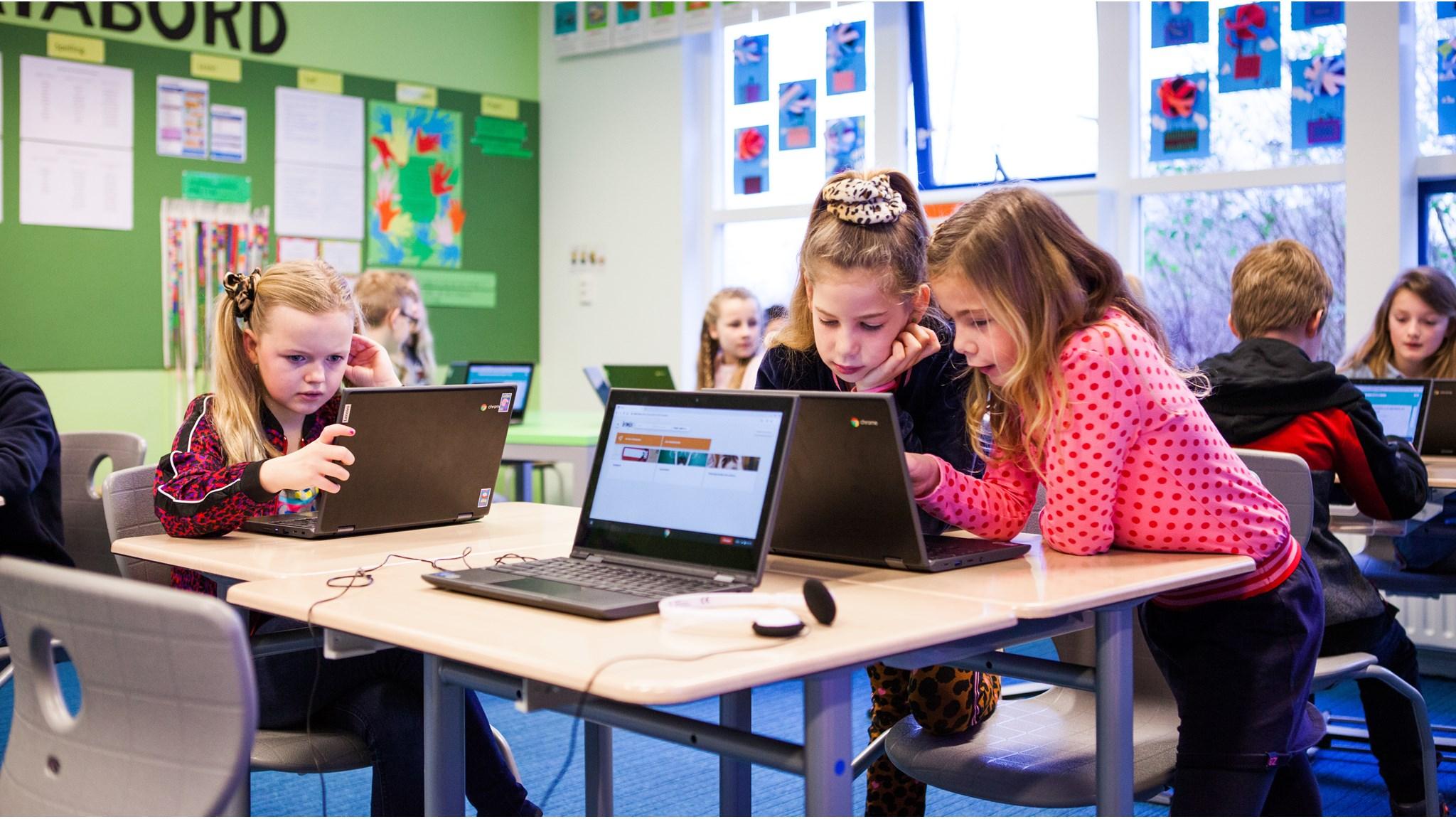 Kinderen van Kids College in Wilnis werken samen aan laptops in hun klaslokaal. Kinderen van Kids College in Wilnis werken samen aan laptops in hun klaslokaal.