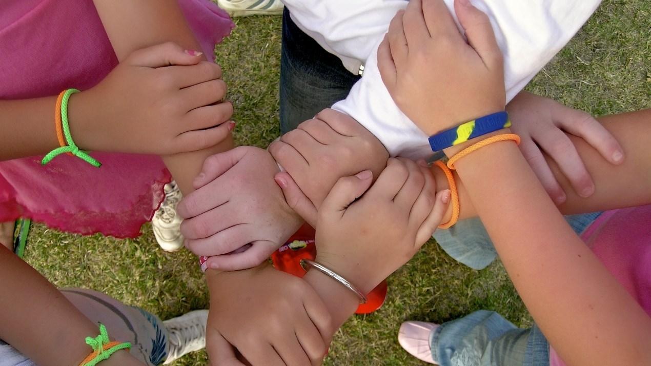 Kinderen van OBS De Pôlle in Marsum houden handen vast in een groepsactiviteit op het schoolplein. Kinderen van OBS De Pôlle in Marsum houden handen vast in een groepsactiviteit op het schoolplein.
