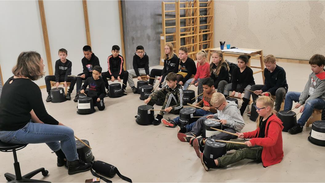 Kinderen van OBS Het Noorderlicht in Hoogezand volgen een muziekles met een docente.