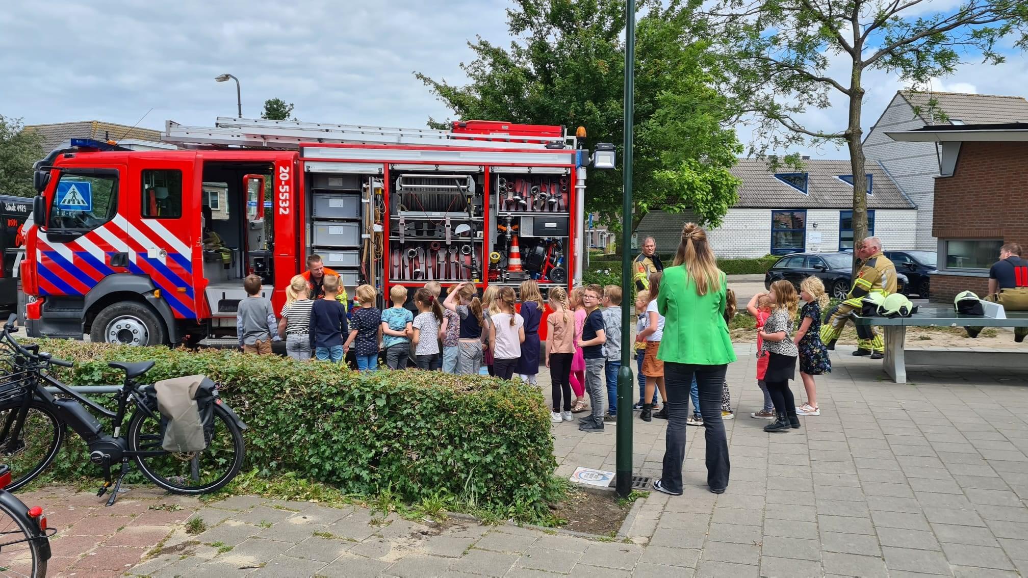 Kinderen van RK Basisschool De Bolderik in Hank luisteren naar een brandweerman bij een brandweerwagen op het schoolplein. Kinderen van RK Basisschool De Bolderik in Hank luisteren naar een brandweerman bij een brandweerwagen op het schoolplein.