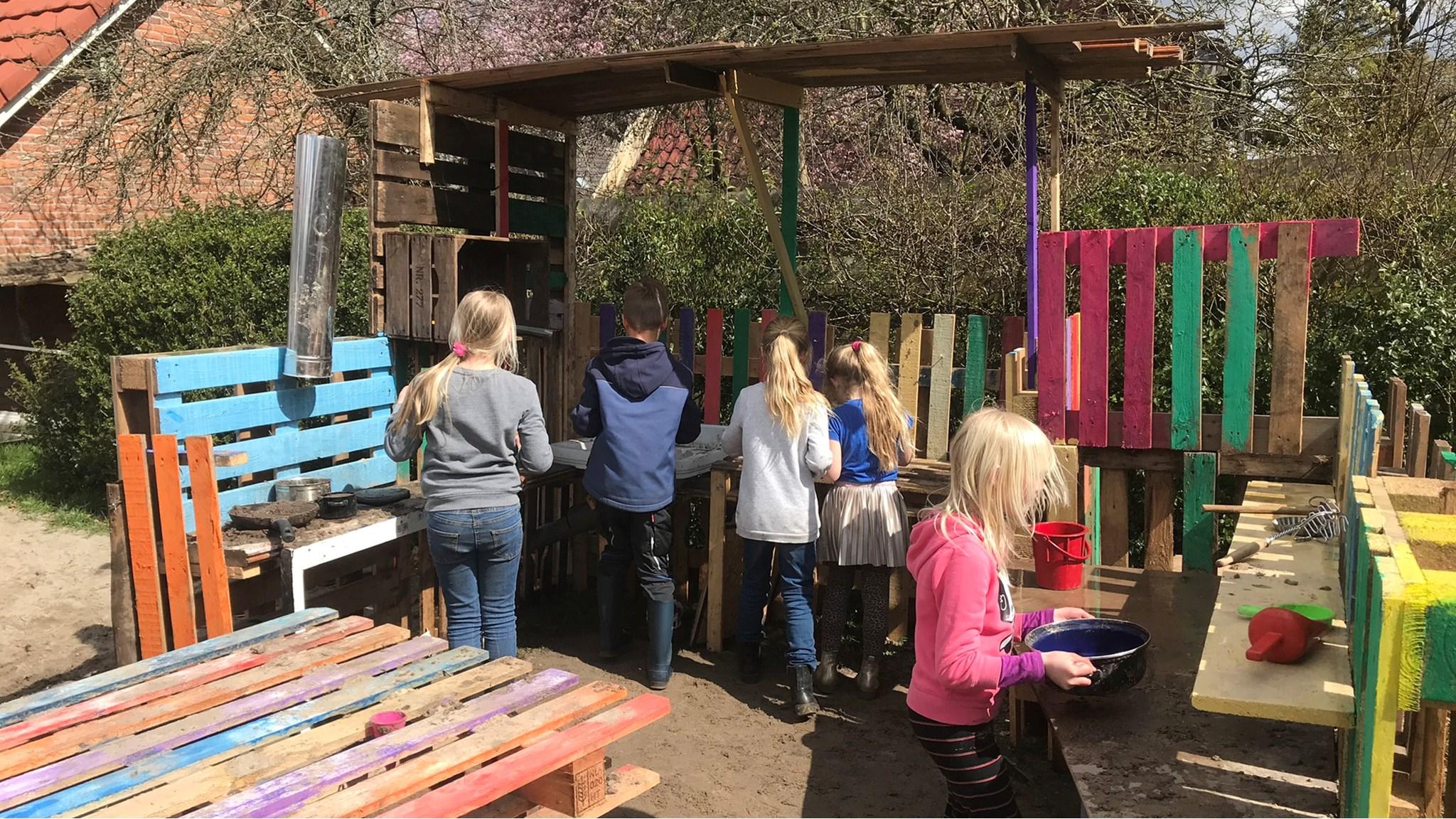 Kinderen van Ten Darperschoele in Wapse spelen creatief op het schoolplein met kleurrijke houten speelstructuren. Kinderen van Ten Darperschoele in Wapse spelen creatief op het schoolplein met kleurrijke houten speelstructuren.
