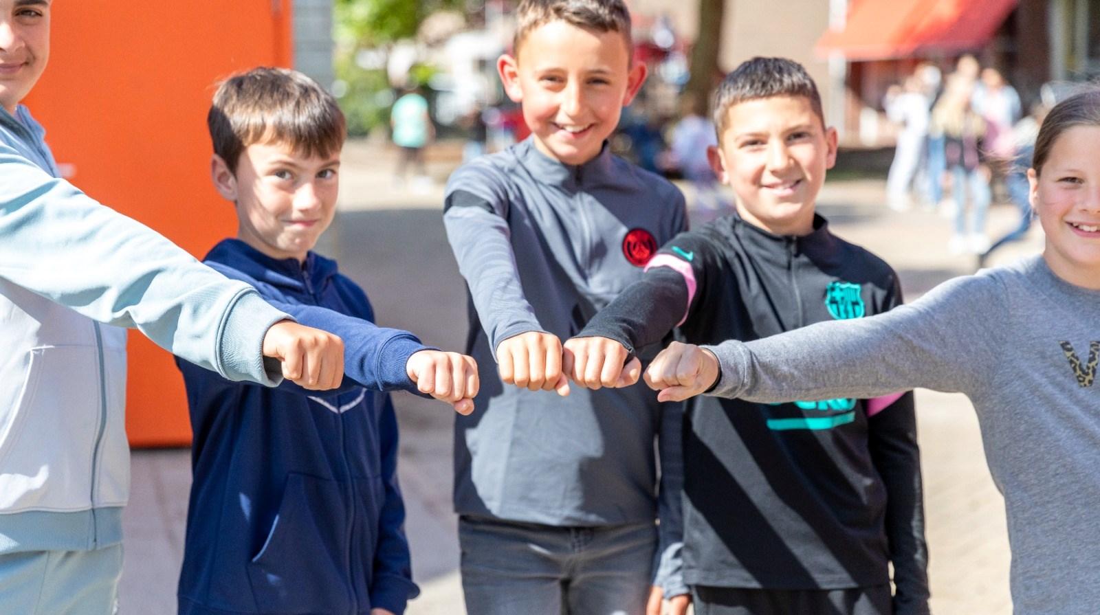 Kinderen van WSKO Basisschool De Nieuwe Weg in Poeldijk geven elkaar een high five op het schoolplein. Kinderen van WSKO Basisschool De Nieuwe Weg in Poeldijk geven elkaar een high five op het schoolplein.