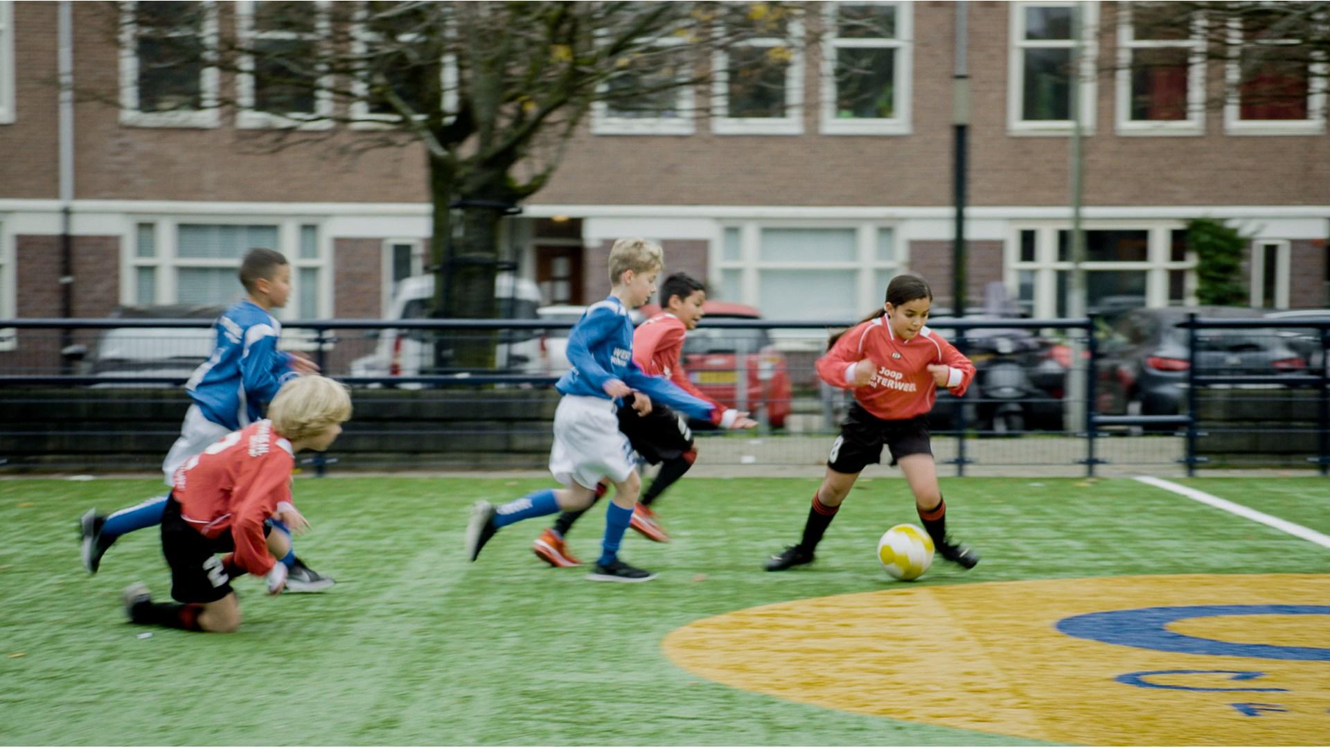 Kinderen voetballen op het schoolplein van Joop en Willy Westerweel in Amsterdam. Kinderen voetballen op het schoolplein van Joop en Willy Westerweel in Amsterdam.