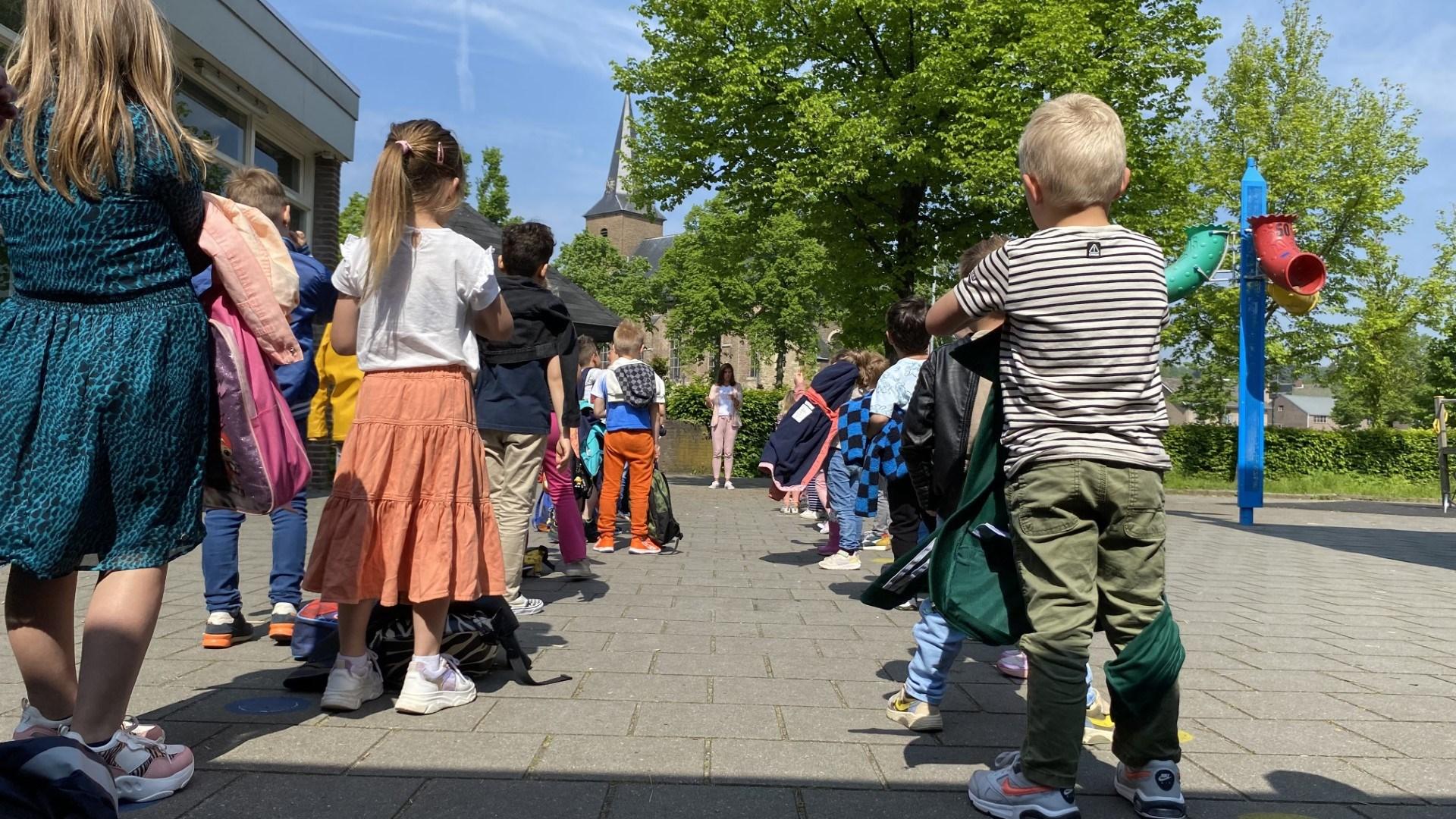 Kinderen wachten in een rij op het schoolplein van Bs Stefanus in Wijnandsrade. Kinderen wachten in een rij op het schoolplein van Bs Stefanus in Wijnandsrade.