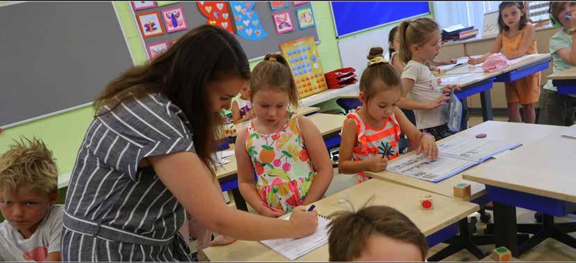 Kinderen werken samen met een docent in de klas van Basisschool De Vlinderboom in Maastricht. Kinderen werken samen met een docent in de klas van Basisschool De Vlinderboom in Maastricht.