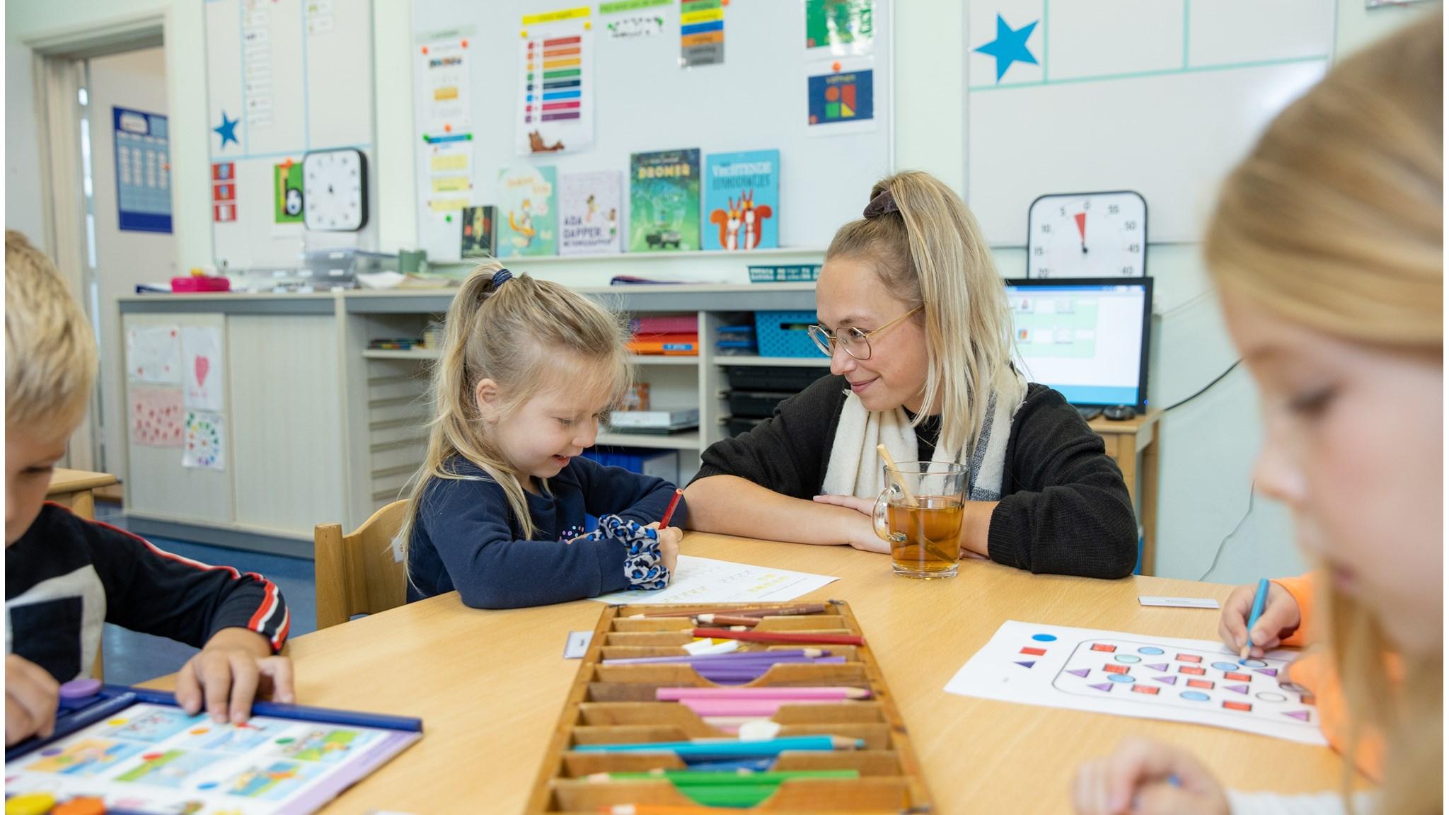 Kinderen werken samen met een lerares aan creatieve activiteiten in de klas van basisschool Ollie B Bommel in Den Bommel. Kinderen werken samen met een lerares aan creatieve activiteiten in de klas van basisschool Ollie B Bommel in Den Bommel.