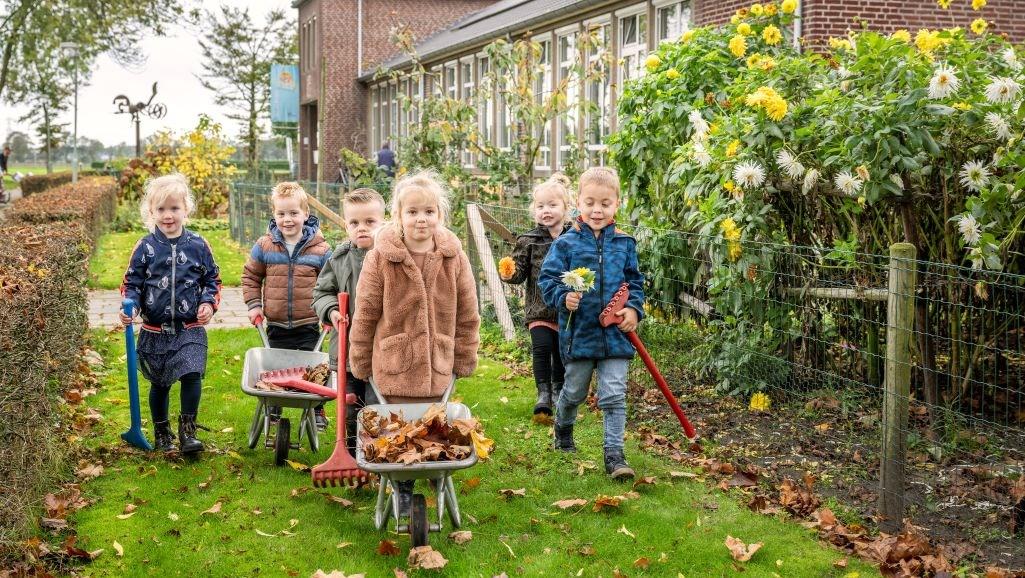 Kinderen zijn bezig met bladeren opruimen op het schoolplein van Basisschool De Kemp in Egchel. Kinderen zijn bezig met bladeren opruimen op het schoolplein van Basisschool De Kemp in Egchel.