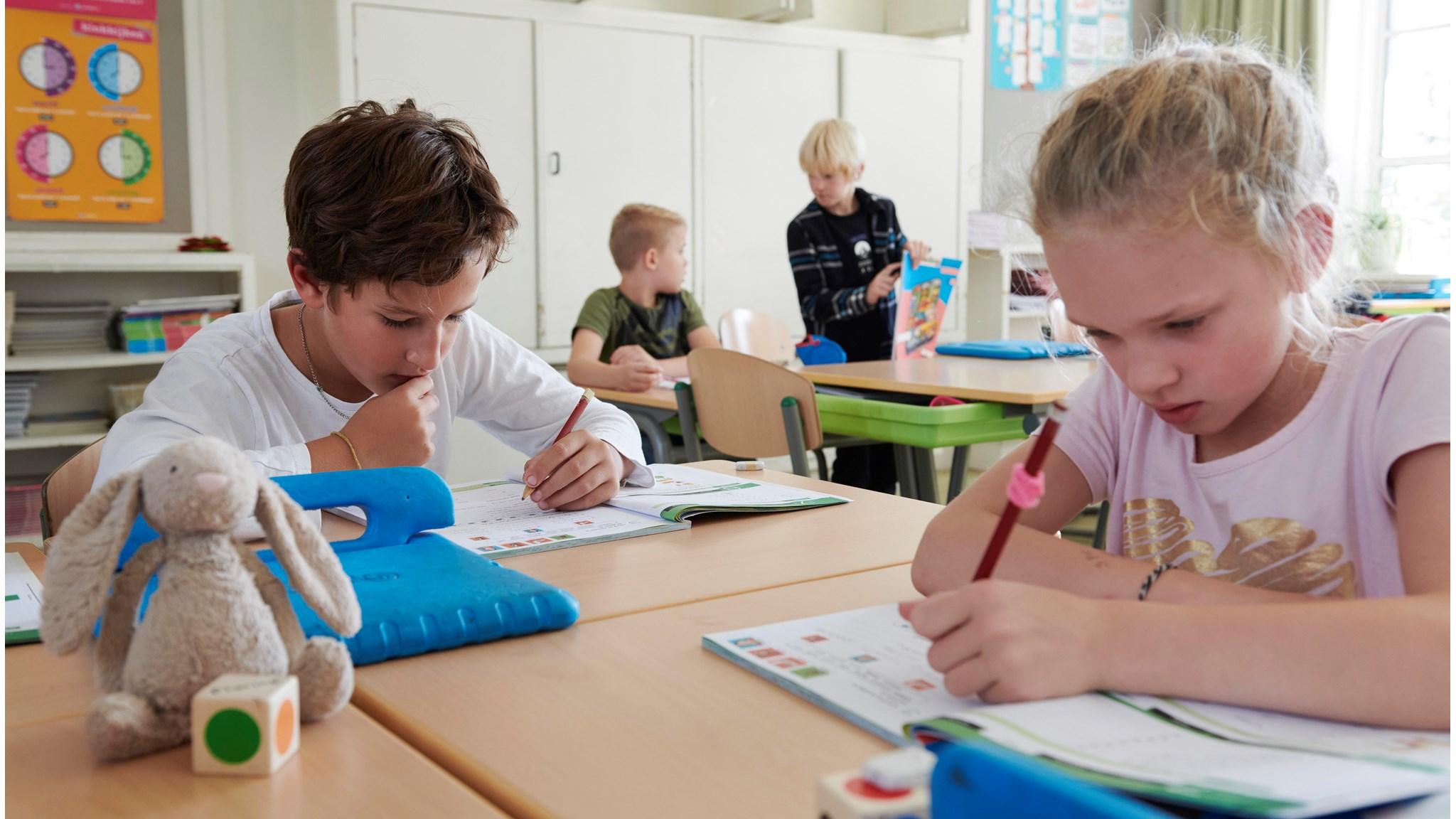 Kinderen zijn geconcentreerd aan het werk in de klas van Openbare Basisschool De Wilgenhoek in Haarlem.