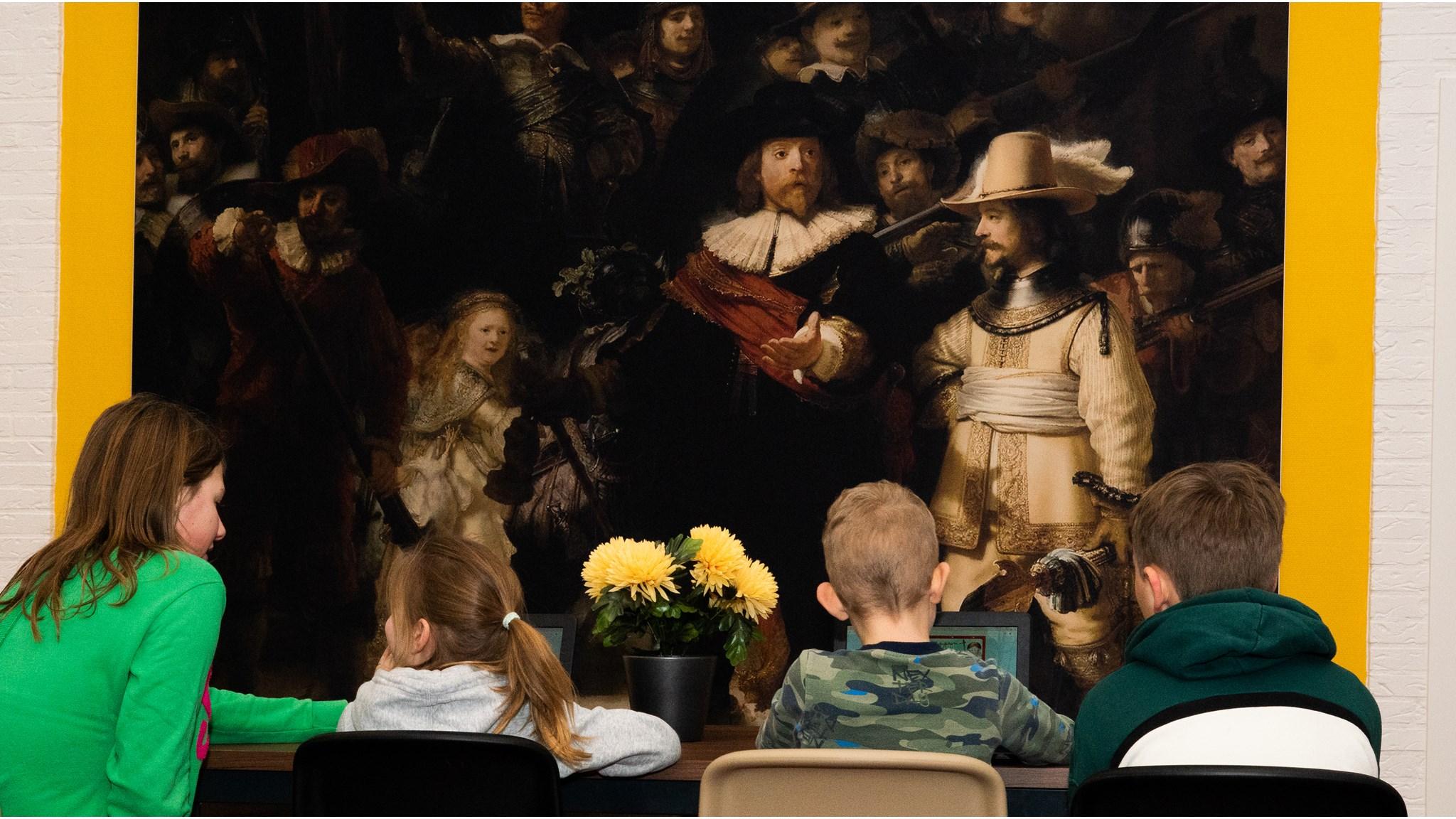 Kinderen zitten in de klas van Basisschool De Tweeklank in Aadorp, met een Rembrandt-schilderij als achtergrond. Kinderen zitten in de klas van Basisschool De Tweeklank in Aadorp, met een Rembrandt-schilderij als achtergrond.