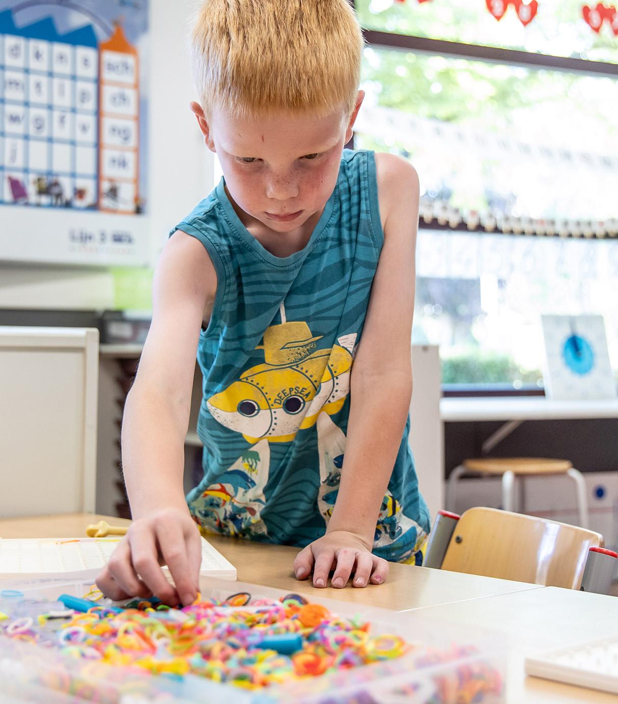 Kindplein 't Centrum in Uden: Een leerling speelt geconcentreerd met kleuren in de klas. Kindplein 't Centrum in Uden: Een leerling speelt geconcentreerd met kleuren in de klas.