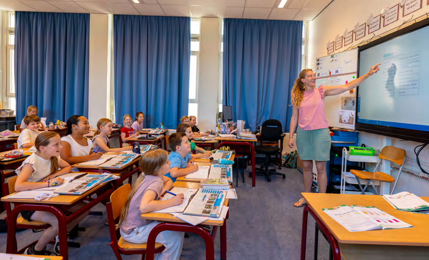 Klaslokaal met enthousiaste leerlingen aan de Prins Mauritsschool in Delft, terwijl de lerares een presentatie geeft. Klaslokaal met enthousiaste leerlingen aan de Prins Mauritsschool in Delft, terwijl de lerares een presentatie geeft.