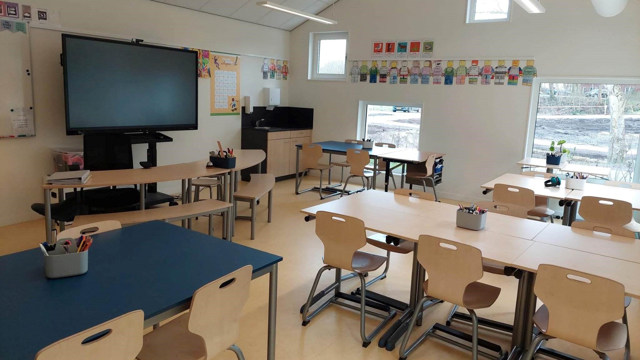 Klaslokaal van De Driebond in Groningen met moderne meubels en een interactief scherm. Klaslokaal van De Driebond in Groningen met moderne meubels en een interactief scherm.