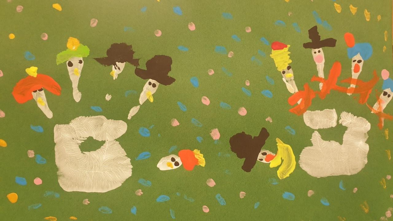 Knutselwerk van leerlingen van basisschool Groene Vallei in Ede met kleurrijke figuren op een groene achtergrond.