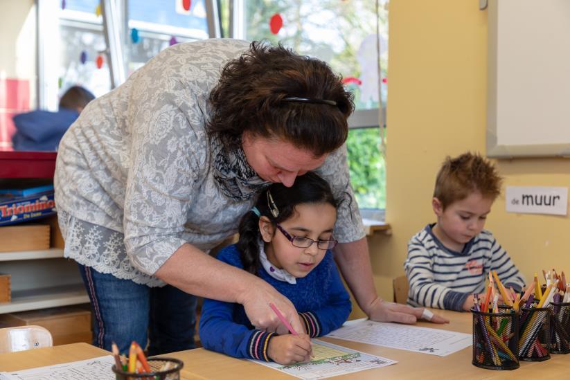 Leerkracht helpt leerling met tekenen in de klas van RK Basisschool St Anna in Zundert. Leerkracht helpt leerling met tekenen in de klas van RK Basisschool St Anna in Zundert.
