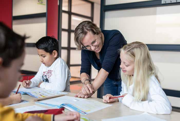 Leerkracht helpt leerlingen met hun werk in De Achtbaan in Tiel. Leerkracht helpt leerlingen met hun werk in De Achtbaan in Tiel.