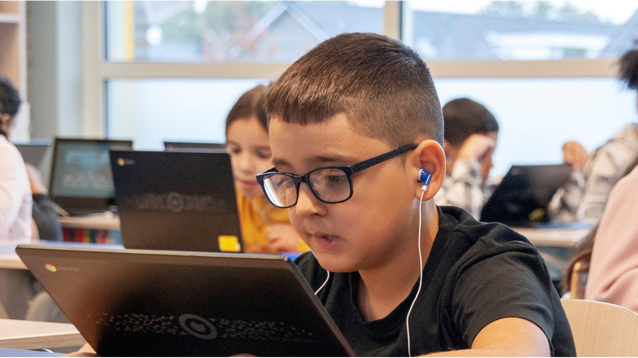 Leerling aan De Achtbaan in Eindhoven werkt geconcentreerd op een laptop in de klas. Leerling aan De Achtbaan in Eindhoven werkt geconcentreerd op een laptop in de klas.