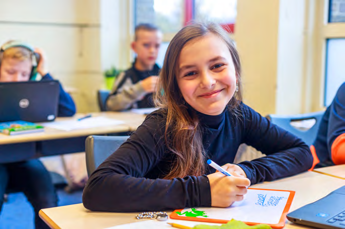Leerling aan de Paulus school in Enschede die glimlachend werkt aan haar opdracht. Leerling aan de Paulus school in Enschede die glimlachend werkt aan haar opdracht.