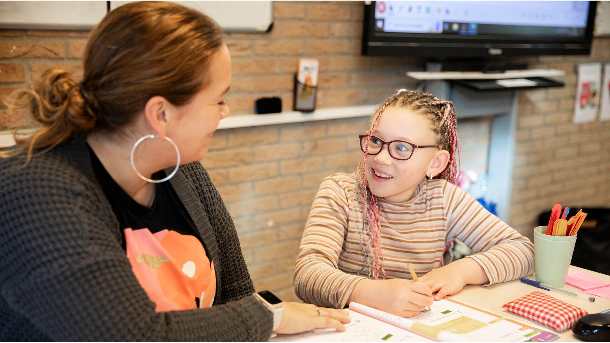 Leerling en leraar in gesprek tijdens een activiteit op CBS De Duif in Spijkenisse. Leerling en leraar in gesprek tijdens een activiteit op CBS De Duif in Spijkenisse.