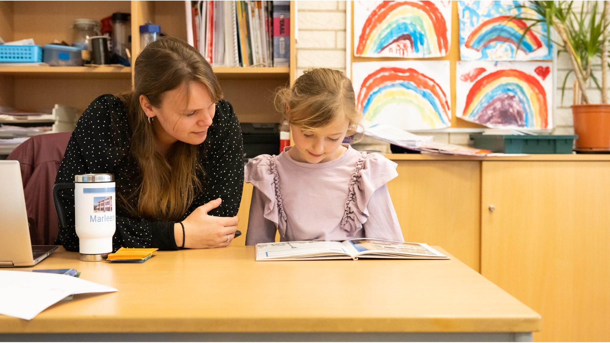 Leerling leest samen met een docente aan Basisschool De Wereldwijzer in Leiden. Leerling leest samen met een docente aan Basisschool De Wereldwijzer in Leiden.