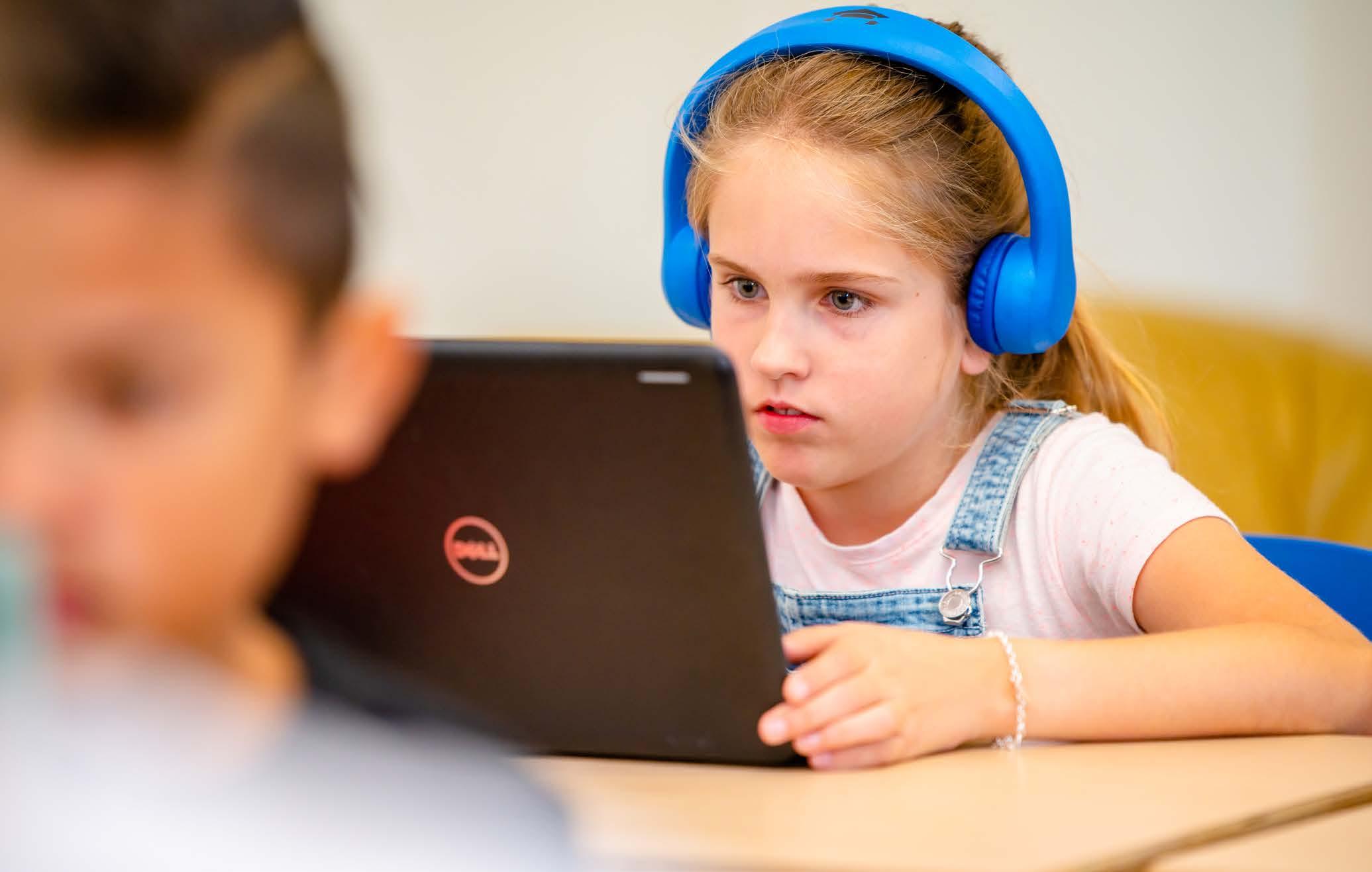 Leerling van Chr. Basisschool Het Mozaiek in Zwolle, gefocust op haar laptop met blauwe hoofdtelefoon. Leerling van Chr. Basisschool Het Mozaiek in Zwolle, gefocust op haar laptop met blauwe hoofdtelefoon.