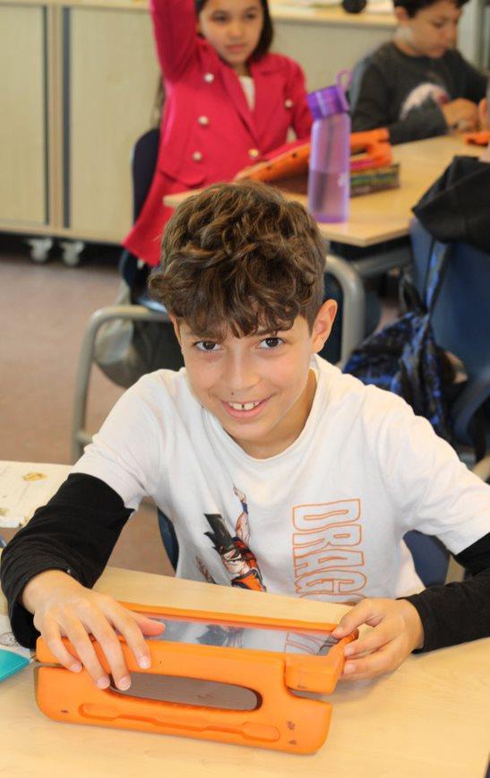 Leerling van de Prinses Marijkeschool in Den Haag zittend aan een tafel met een tablet. Leerling van de Prinses Marijkeschool in Den Haag zittend aan een tafel met een tablet.