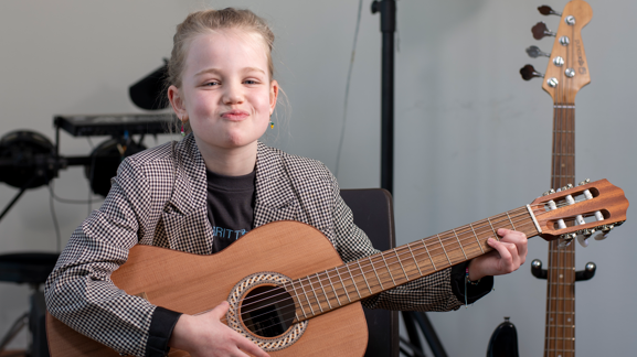Leerling van Openbare Basisschool Hurdegarijp speelt gitaar en straalt zelfvertrouwen uit. Leerling van Openbare Basisschool Hurdegarijp speelt gitaar en straalt zelfvertrouwen uit.