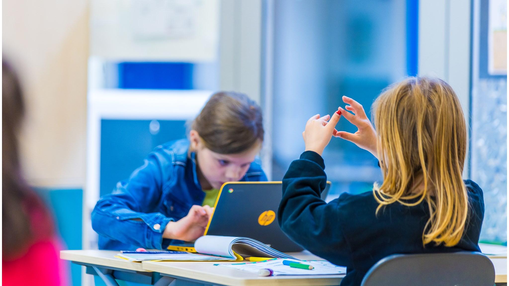 Leerlingen aan Basisschool De Triangel in Grijpskerk zijn bezig met creatieve taken aan hun desks.