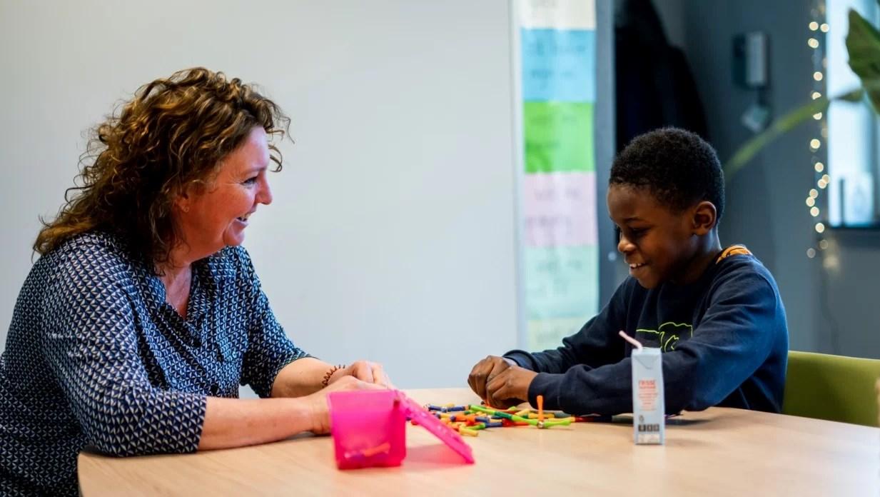 Leerlingen en docenten van de dr. Willem Dreesschool in Den Haag genieten van een educatieve activiteit aan tafel. Leerlingen en docenten van de dr. Willem Dreesschool in Den Haag genieten van een educatieve activiteit aan tafel.
