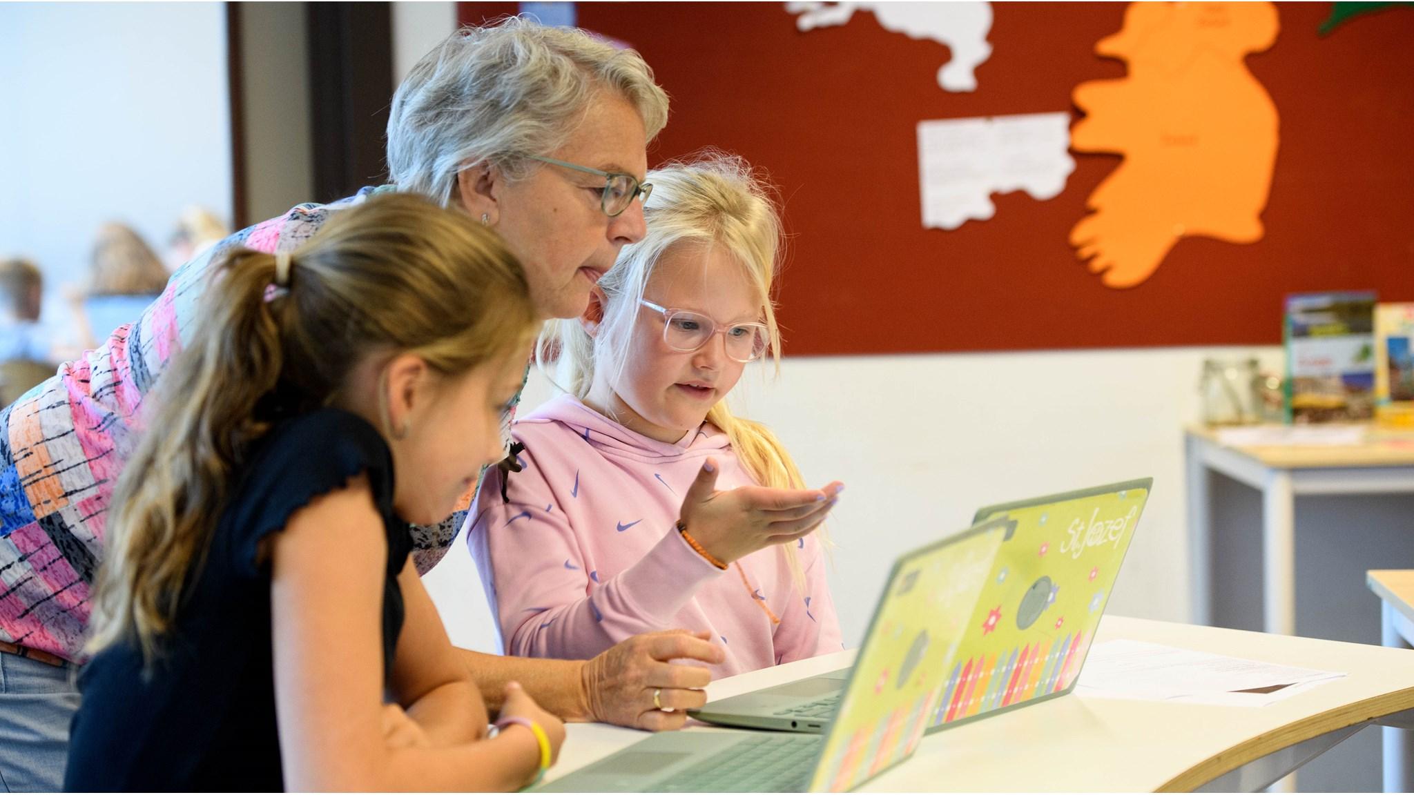 Leerlingen en een docent van RKBS St. Jozef in Zwaagdijk-Oost werken samen aan een computer. Leerlingen en een docent van RKBS St. Jozef in Zwaagdijk-Oost werken samen aan een computer.