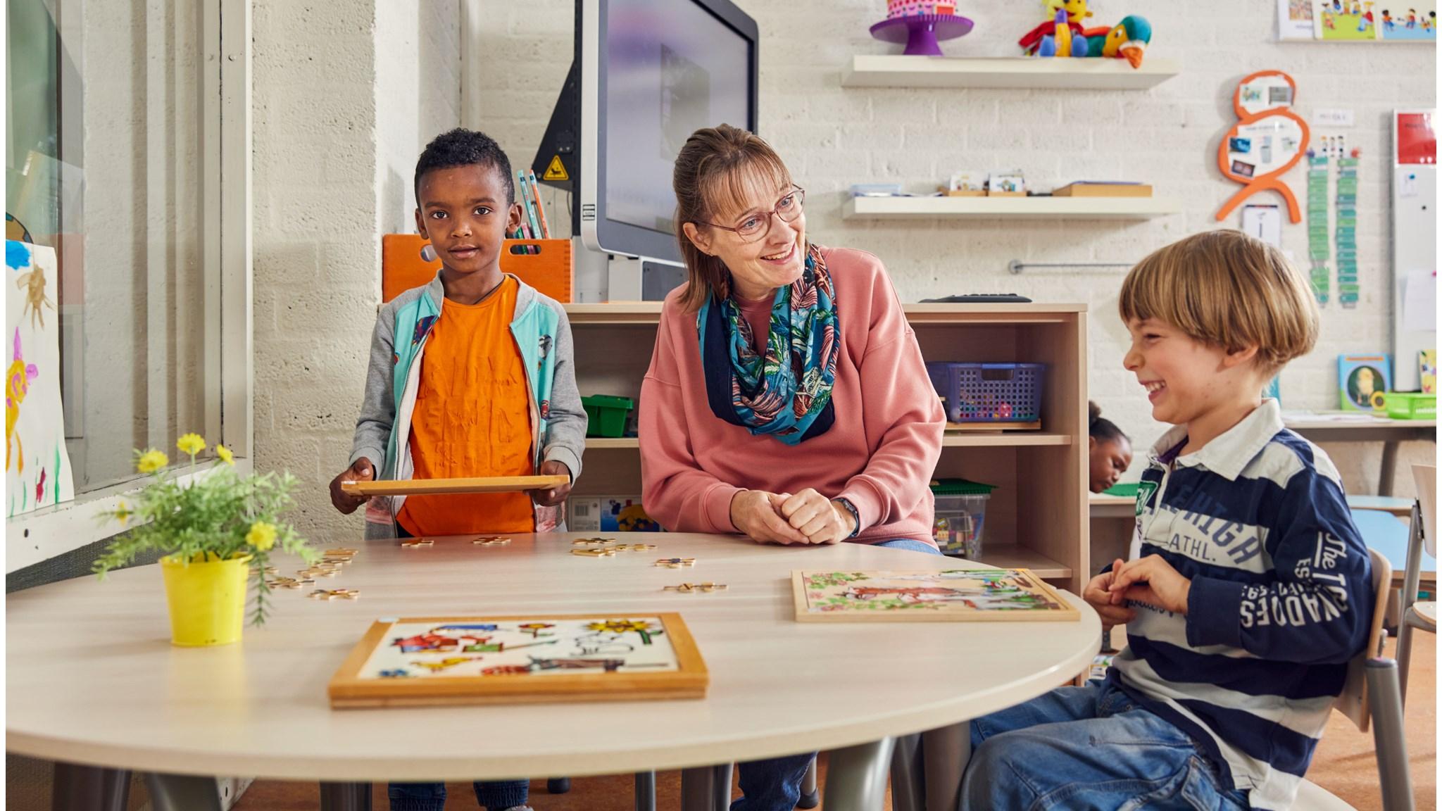 Leerlingen en een lerares werken samen aan puzzels in De Achtsprong, openbare daltonschool in Woerden. Leerlingen en een lerares werken samen aan puzzels in De Achtsprong, openbare daltonschool in Woerden.