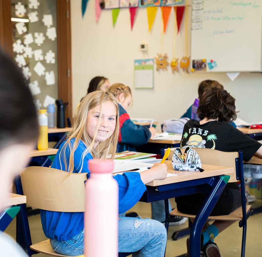 Leerlingen in een klaslokaal van de Fatimaschool in Rotterdam, met een glimlachende leerling op de voorgrond. Leerlingen in een klaslokaal van de Fatimaschool in Rotterdam, met een glimlachende leerling op de voorgrond.