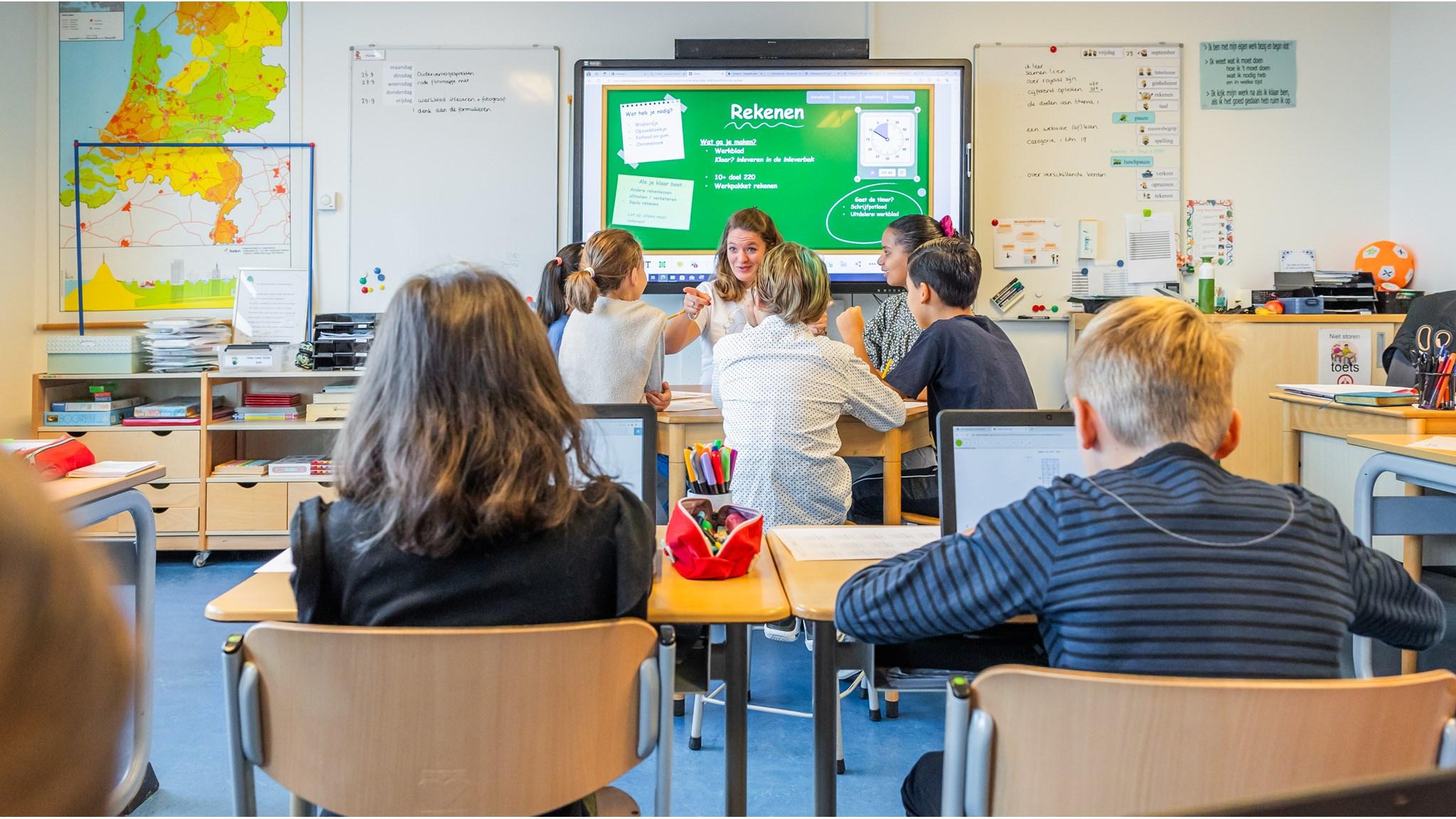 Leerlingen in een klaslokaal van De Zonnewijzer in Bussum zijn actief betrokken bij een rekenles met technologie. Leerlingen in een klaslokaal van De Zonnewijzer in Bussum zijn actief betrokken bij een rekenles met technologie.