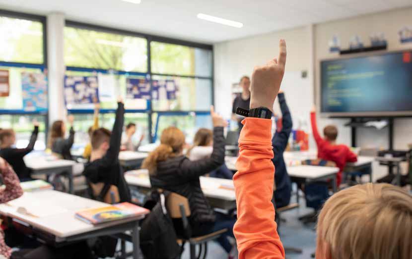 Leerlingen in een klaslokaal van Het Baken I in Veenendaal steken hun hand op om te antwoorden. Leerlingen in een klaslokaal van Het Baken I in Veenendaal steken hun hand op om te antwoorden.