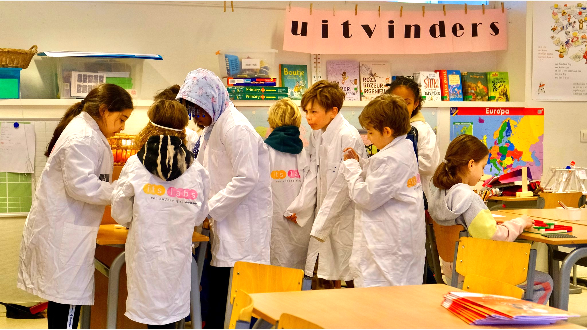 Leerlingen in laboratoriumjassen werken samen aan een project in De Zuiderzee in Amsterdam. Leerlingen in laboratoriumjassen werken samen aan een project in De Zuiderzee in Amsterdam.