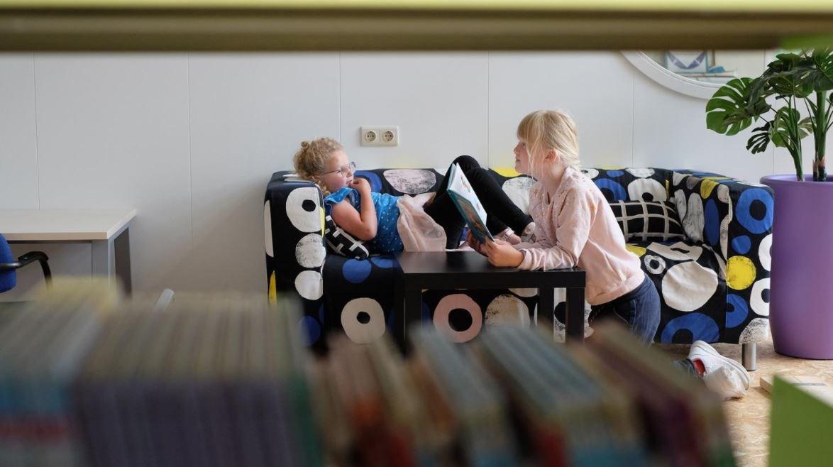 Leerlingen lezen en ontspannen samen op een kleurrijke bank in Basisschool De Waayer in Tiel. Leerlingen lezen en ontspannen samen op een kleurrijke bank in Basisschool De Waayer in Tiel.