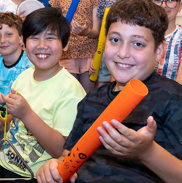Leerlingen met kleurrijke stokken genieten van een activiteit op de Prins Mauritsschool in Delft. Leerlingen met kleurrijke stokken genieten van een activiteit op de Prins Mauritsschool in Delft.