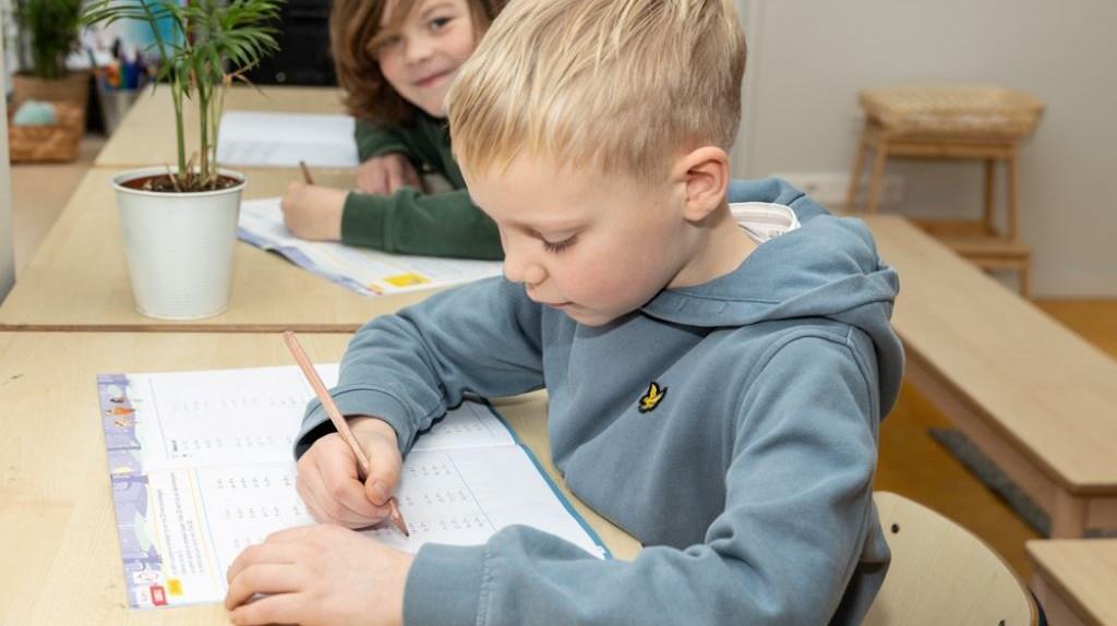 Leerlingen schrijven in een klaslokaal van Openbare Jenaplan Basisschool Oldenije in Leeuwarden.