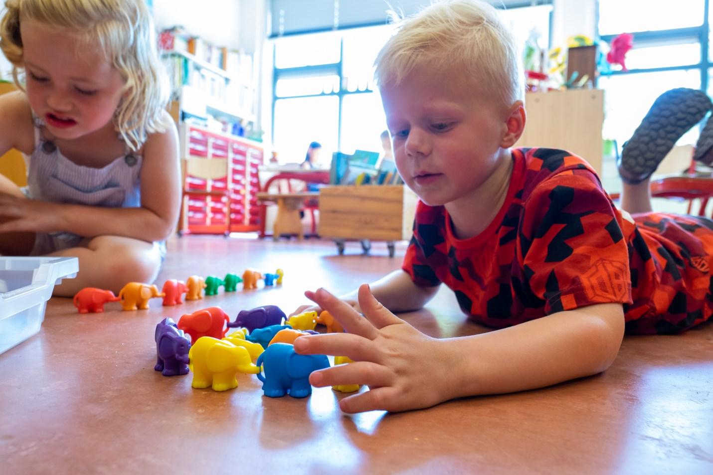 Leerlingen spelen met kleurrijke olifanten op de vloer in Openbare Basisschool de Cocon in Alkmaar. Leerlingen spelen met kleurrijke olifanten op de vloer in Openbare Basisschool de Cocon in Alkmaar.