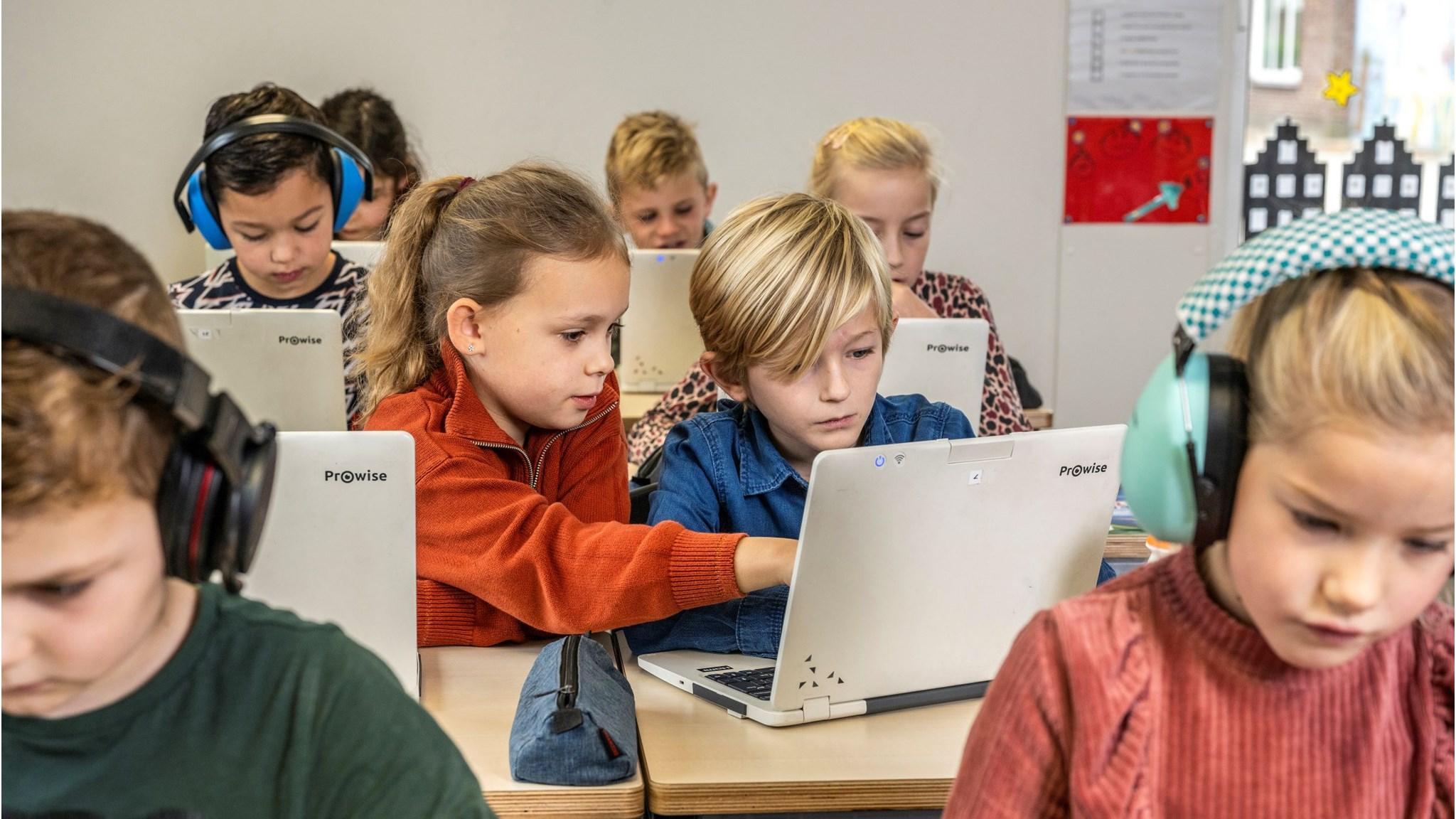 Leerlingen van Basisschool De Kemp in Egchel werken samen met laptops in de klas. Leerlingen van Basisschool De Kemp in Egchel werken samen met laptops in de klas.