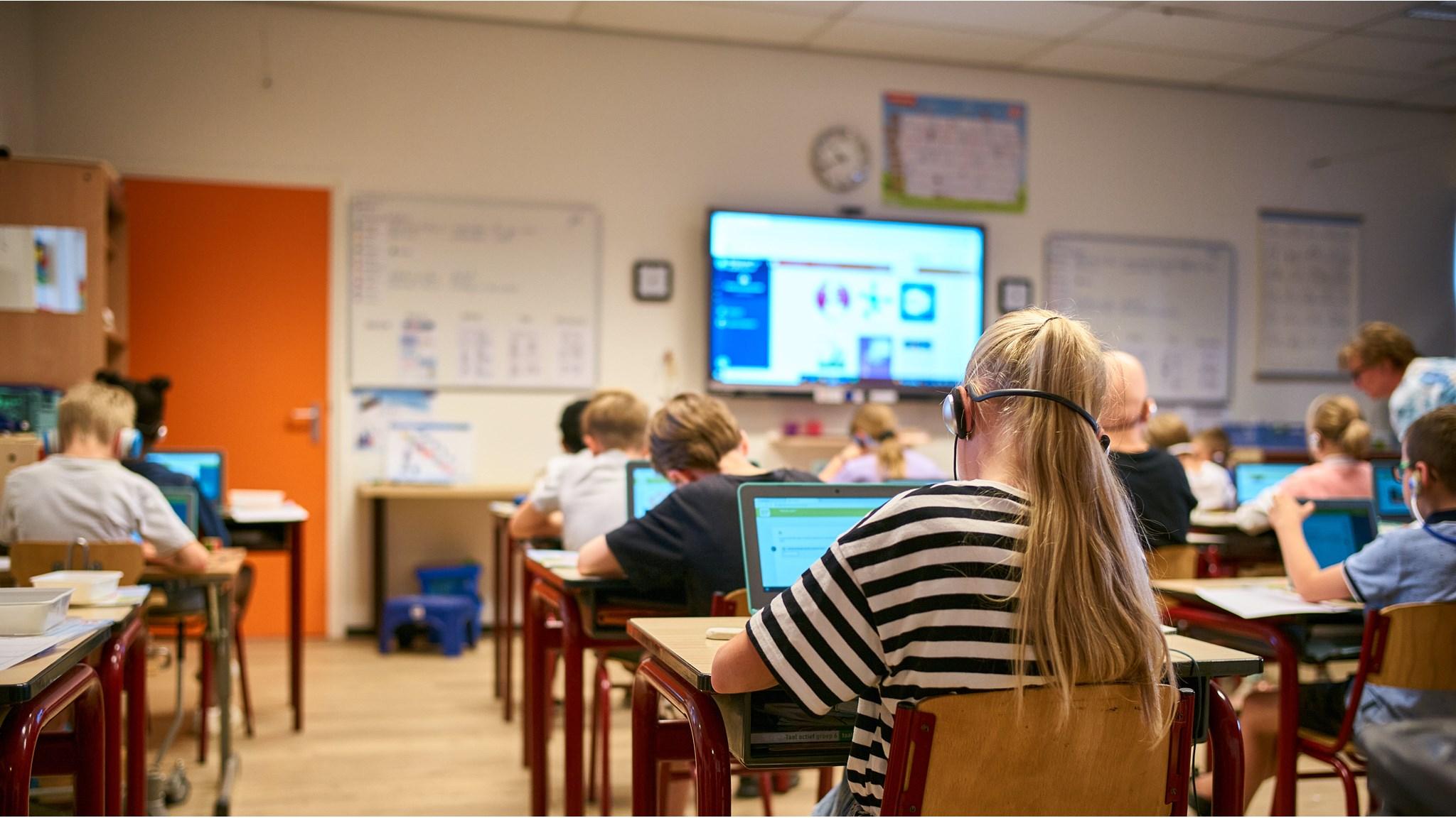 Leerlingen van Basisschool De Krabbenkooi in Bergen op Zoom werken geconcentreerd aan hun laptops in de klas. Leerlingen van Basisschool De Krabbenkooi in Bergen op Zoom werken geconcentreerd aan hun laptops in de klas.