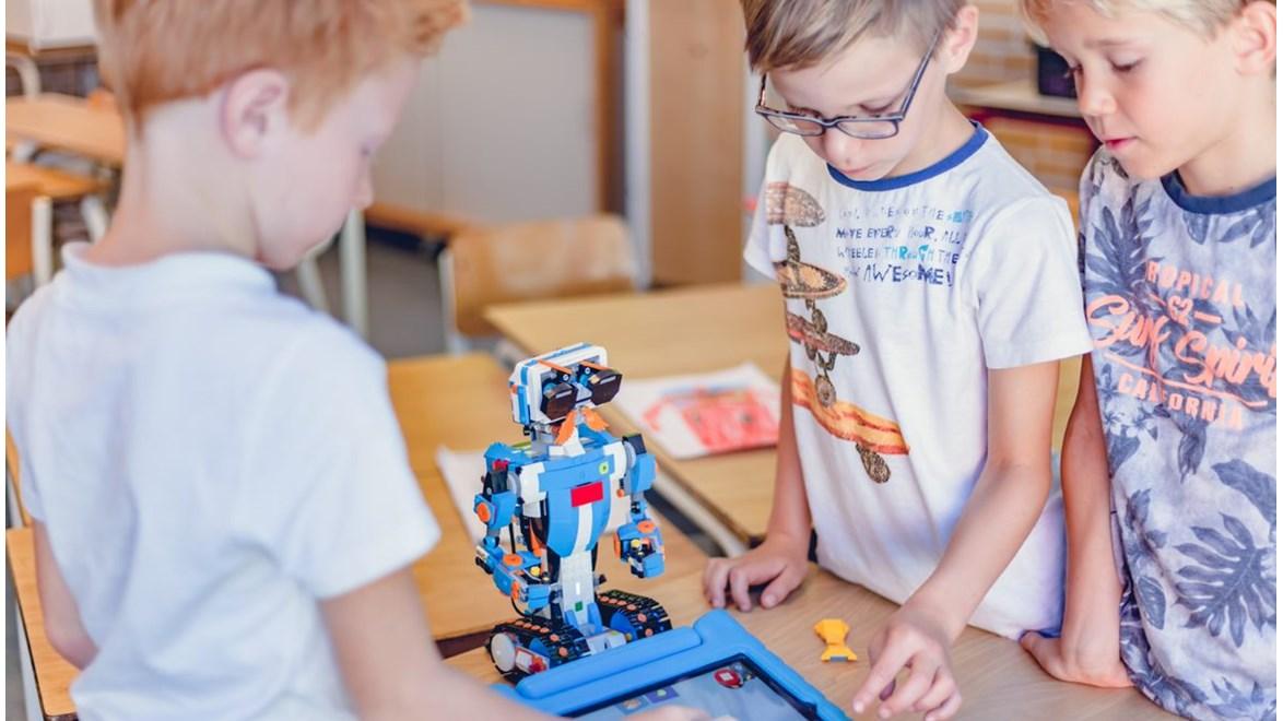 Leerlingen van Basisschool De Maten in Oldenzaal werken samen met een robot en tablet in de klas. Leerlingen van Basisschool De Maten in Oldenzaal werken samen met een robot en tablet in de klas.