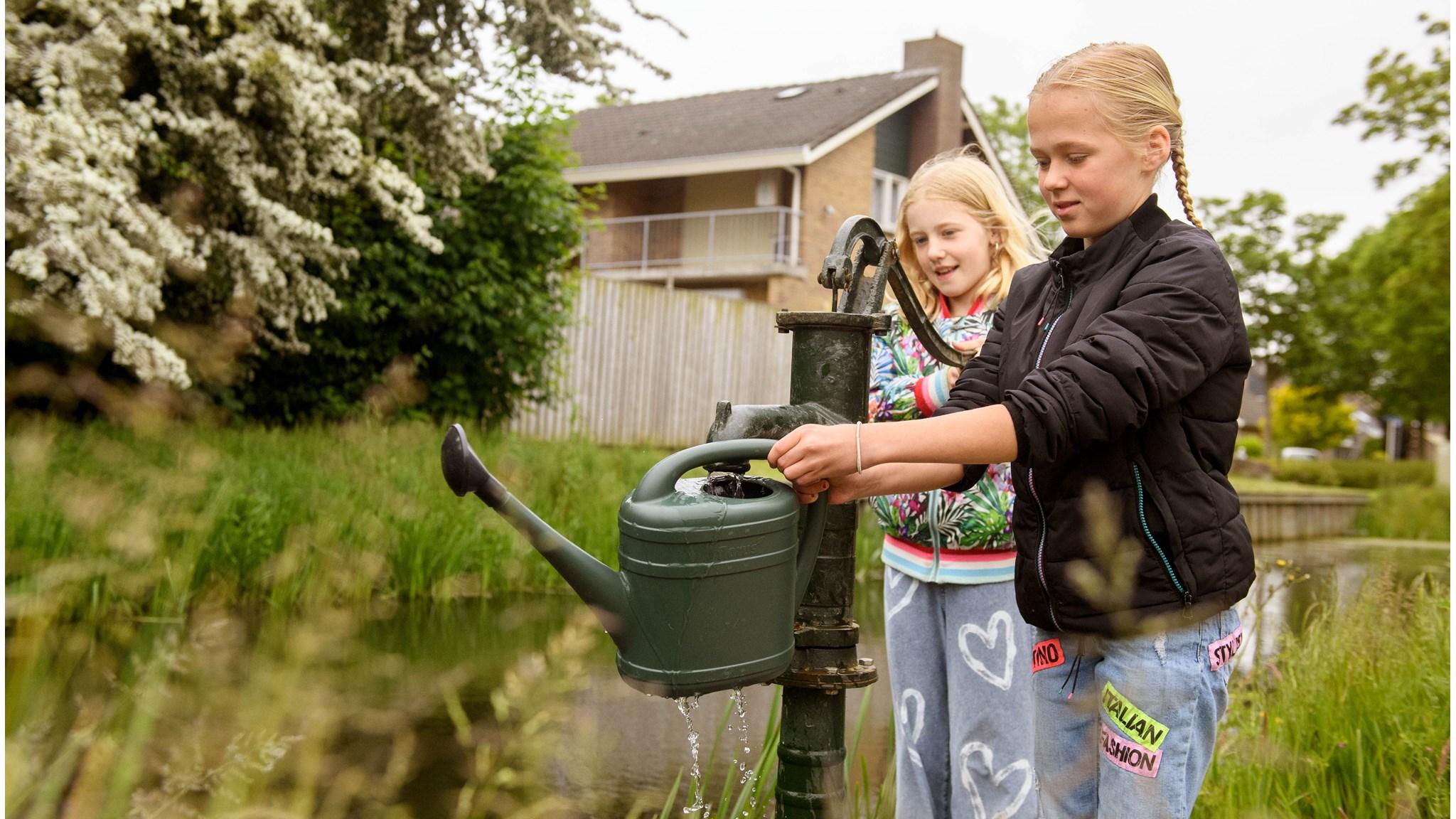 Leerlingen van Basisschool De Schelp in Wervershoof gebruiken een waterpomp op het schoolplein. Leerlingen van Basisschool De Schelp in Wervershoof gebruiken een waterpomp op het schoolplein.