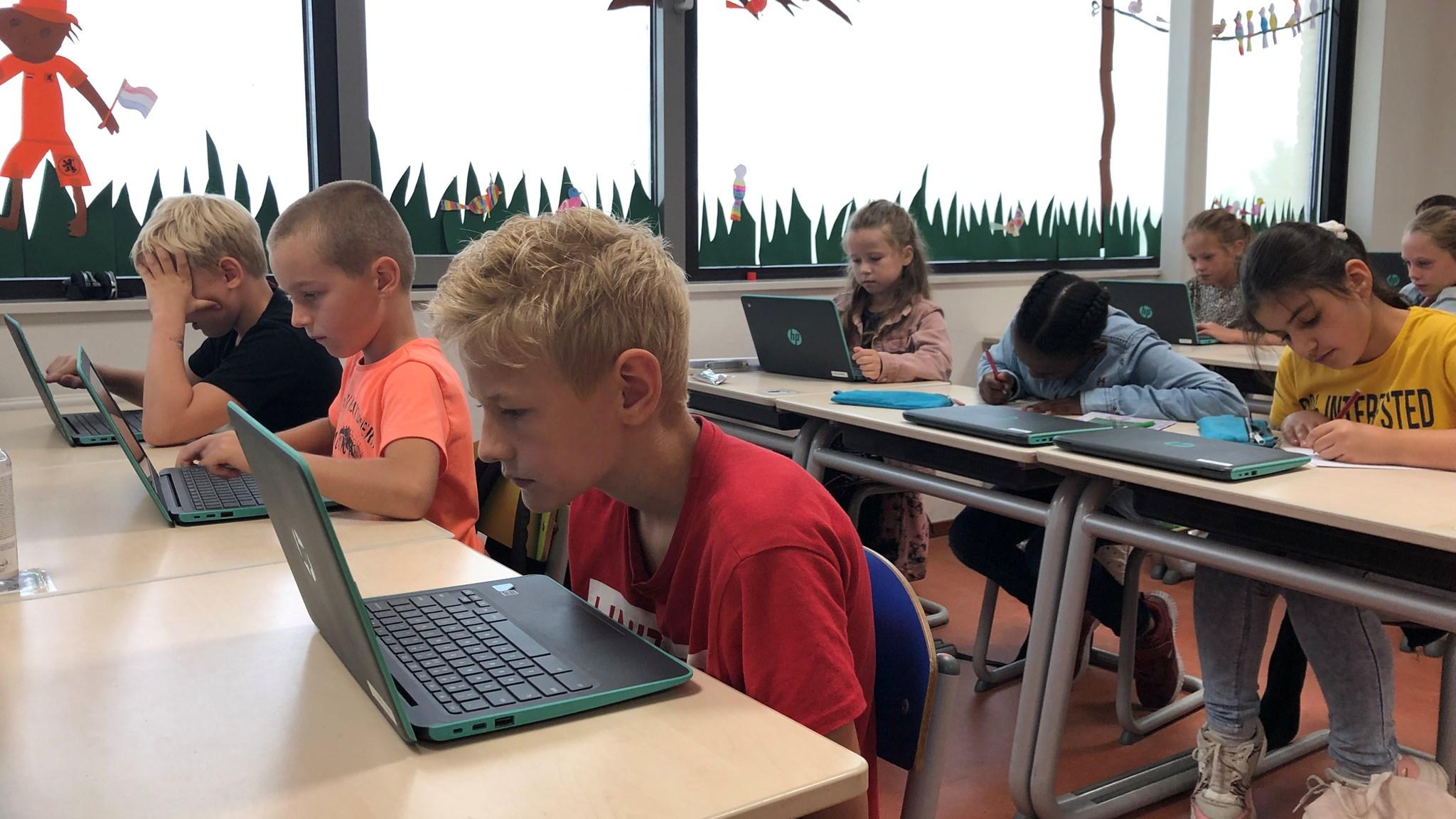 Leerlingen van Basisschool De Wegwijzer in Driebruggen zijn aan het werk op laptops in de klas. Leerlingen van Basisschool De Wegwijzer in Driebruggen zijn aan het werk op laptops in de klas.