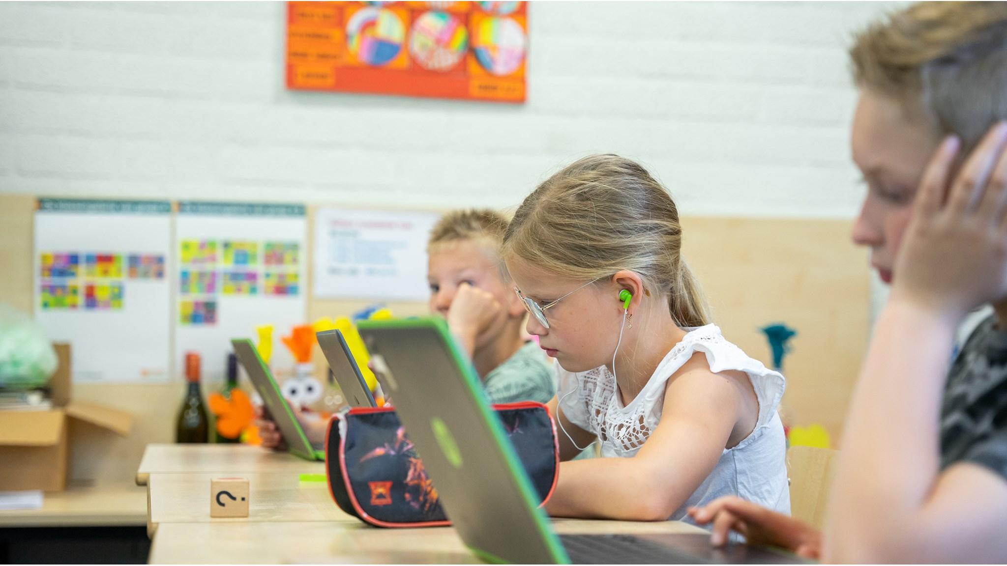 Leerlingen van Basisschool De Wingerd in Nijverdal zijn geconcentreerd aan het werk met laptops in de klas. Leerlingen van Basisschool De Wingerd in Nijverdal zijn geconcentreerd aan het werk met laptops in de klas.