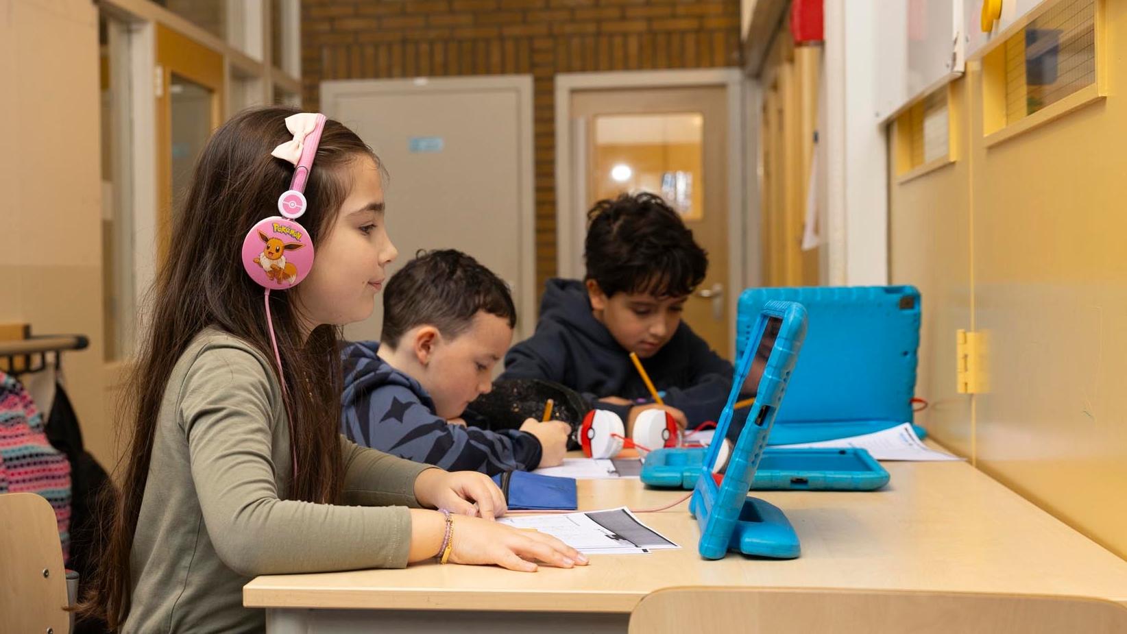 Leerlingen van basisschool Delfshaven in Rotterdam werken geconcentreerd aan hun taken met tablets en schriften. Leerlingen van basisschool Delfshaven in Rotterdam werken geconcentreerd aan hun taken met tablets en schriften.