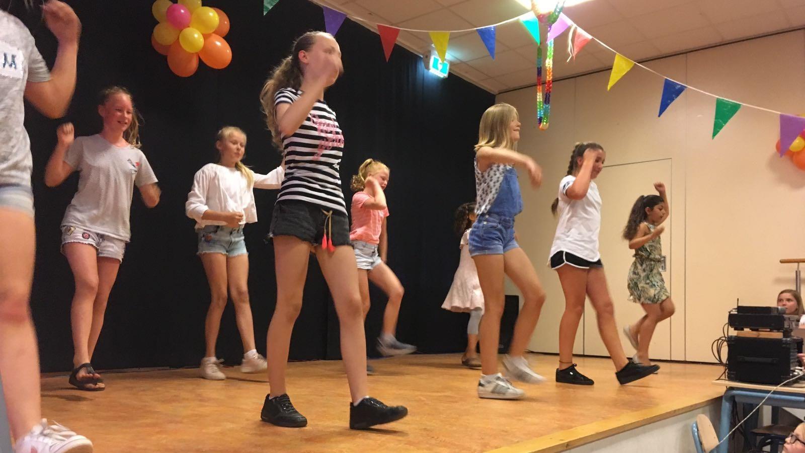 Leerlingen van Basisschool Sint Jozef in Wassenaar zijn aan het dansen op een podium tijdens een schoolactiviteit. Leerlingen van Basisschool Sint Jozef in Wassenaar zijn aan het dansen op een podium tijdens een schoolactiviteit.