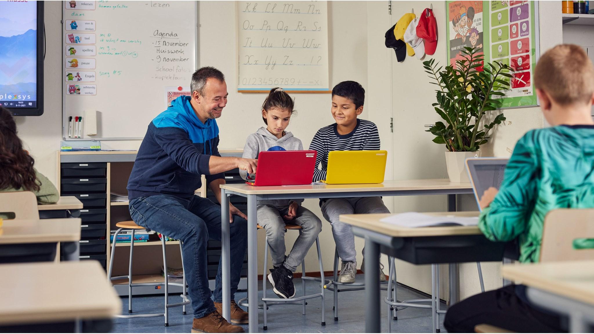 Leerlingen van Basisschool 't Palet' in Gouda werken samen met de leraar aan laptops in de klas. Leerlingen van Basisschool 't Palet' in Gouda werken samen met de leraar aan laptops in de klas.