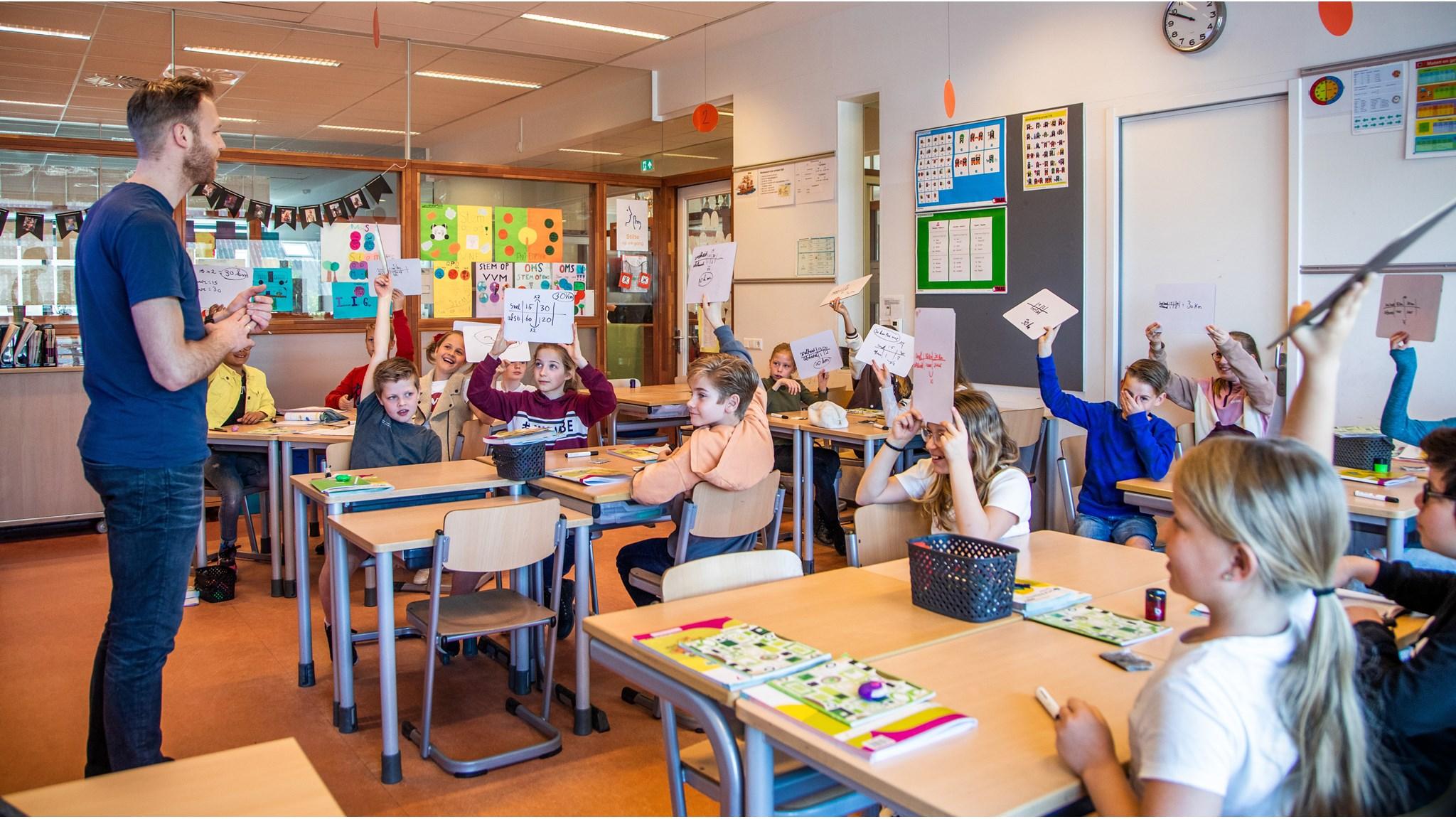 Leerlingen van Blink in Vleuten nemen actief deel aan de les door hun antwoorden omhoog te houden. Leerlingen van Blink in Vleuten nemen actief deel aan de les door hun antwoorden omhoog te houden.